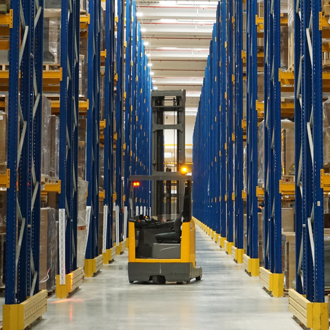 un carrello elevatore tra le scaffalature del magazzino